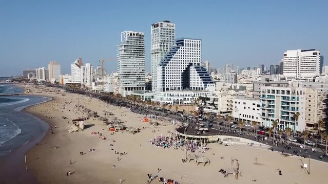 Israel tel aviv  2022, Panning aerial view of people swimming and relaxing on the beach in Tel Aviv, in front of hotels, offices, and apartments buildings. Popular holiday destination  in Israel. 