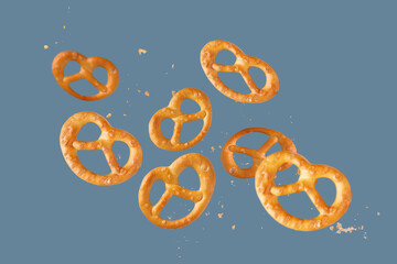 salty pretzels are scattered on a blue background