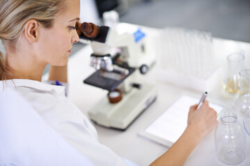 Logging her findings online. Shot of a beautiful young scientist recording her findings on a tablet.