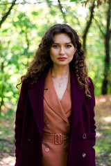 Beautiful girl in the autumn park. Burgundy coat. The girl is walking in the park.