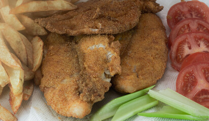 Catfish and french fries with side vegetables