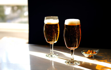 Two glasses of light beer on the table.