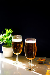 Two glasses of light beer on the table.