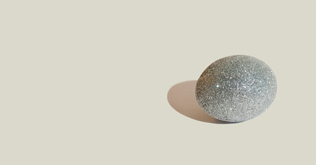 Glitter silver eggs on gray background. Minimal Easter background. Greeting card. Space for text. Banner