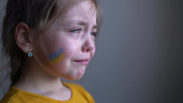 Upset Ukrainian girl kid crying protesting war conflict. Crisis, peace, stop aggression, child against Russian war