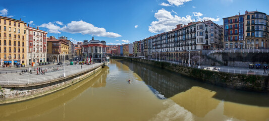Panoramic view of the river in the city of Bilbao on a day with a blue sky and some white clouds. Bilbao, Spain, 03-27-2022