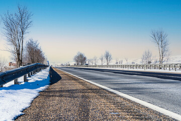 Obraz premium Empty asphalt road in snow, highway