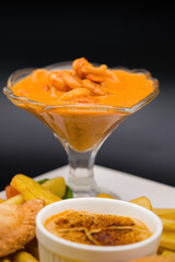 shrimp and squid rings in sauce, served in a glass cup, isolated background