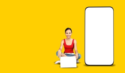 Big phone behind woman. Girl is sitting with laptop. Big blank screen smartphone.