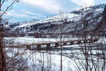 Winter snowy landscape, river with river and bridge