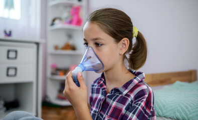 Little girl using inhaler at home. Health care concept