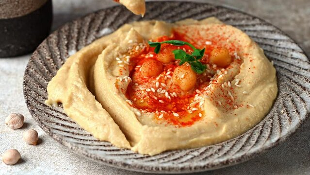 Eating hummus with crispbread. hummus with sesame, olive oil and paprika. Healthy vegan food. Vegetarian dish. Mezze chickpeas. Kosher food.