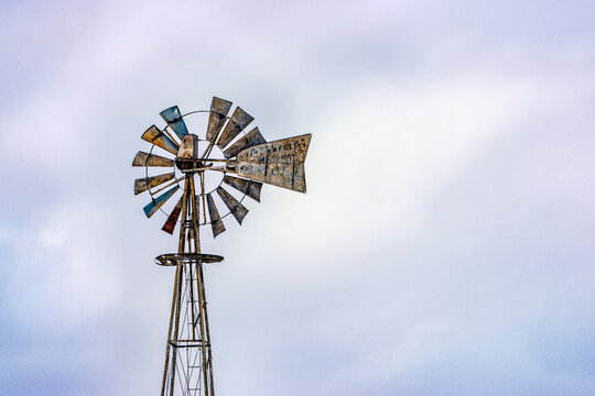 Rural windmill in the sky with missing blade.