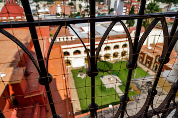 Courtyard of a convent seen through a window with focus on the grille in Salta, Argentina