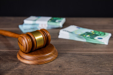 Wooden judge gavel and money on the table
