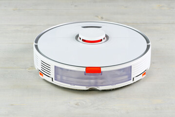 robot vacuum cleaner on the wooden floor cleaning the room. Smart cleaning and washing technology. advanced robot work to vacuum then mop. close up