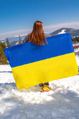 Woman holding,fluttering,waving ukrainian national blue yellow flag.war,conflict,military invasion beetwen Russia as terrorist aggressive country and Ukraine.Ukraines Independence,Constitution day