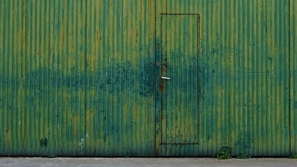 green rusty industrial metal door as background