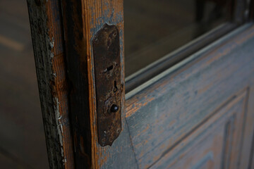 昔の小学校の扉につけられた錆びたカギ