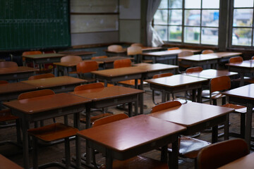 昔の小学校の教室に並べられた机とイス（岡山県真庭市 旧遷喬尋常小学校）