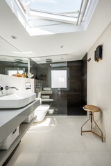 Attic toilet, decorative orange vases, porcelain sink, shower stall with screen, gold metal stool and long mirror and modern mosaic
