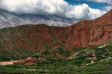 Red hill with small adobe buildings in Salta, Argentina