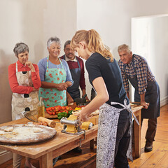 Nothing brings people together like good food. Shot of a group of seniors attending a cooking class.