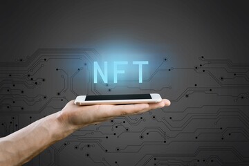 NFT non fungible tokens concept. Businessman with smartphone holding digital hologram