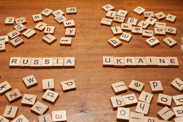 russia and ukraine letters on wooden background