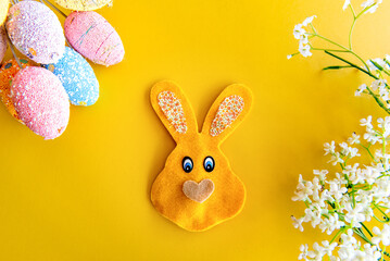 Easter decoration, stuffed bunny on yellow background.