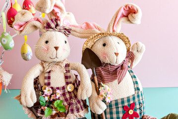Easter decoration, stuffed rabbits on pink background.