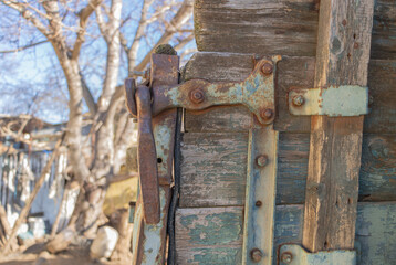 Closeup of a wooden door with a rusty metal handle