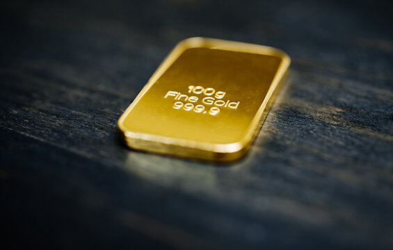 100g Gold bar on wooden background