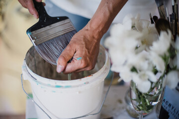 Closeup of woman's hands as she washes paint brushes.