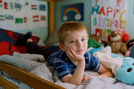 A little boy lies in his bed.