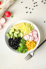 Bowl with ingredients for Mexican vegetable salad on light background