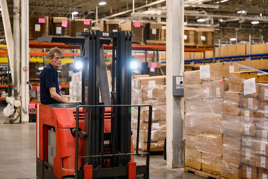 Loading dock driver moving goods at warehouse 