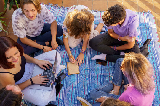 Teens planning trip on terace floor