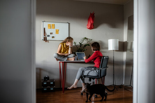 The child is next to the mother at home