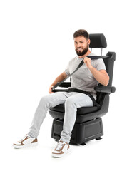 Young man fastening in car seat on white background