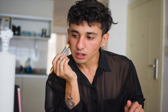 Gender fluid person applying blush