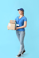 Female courier with parcels on color background