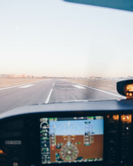 Cockpit of a small plane landing on the airport runway at sunset