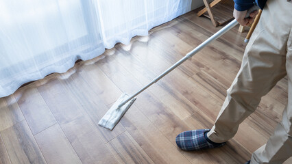 床用クリーナーで掃除する男性
