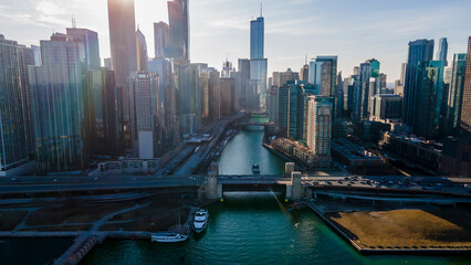 Fototapeta na wymiar Chicago, IL USA- march 13th 2022: aerial drone shot of downtown Chicago by the river during early spring summer. the beautiful skyscrapers look futuristic along the green lake water
