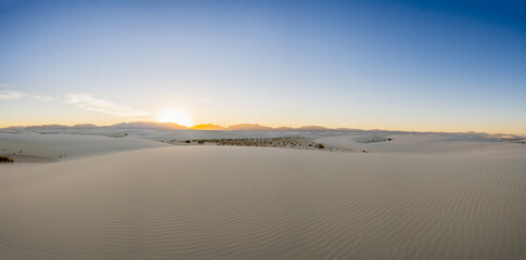 Fototapeta na wymiar Panorama Of Sun Setting Over The Vast Emptiness of White Sand Dunes