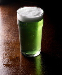 st. patricks pint of green beer  on wooden table