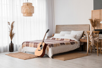 Interior of modern bedroom with guitar