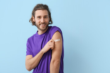 Young man with applied medical patch on color background