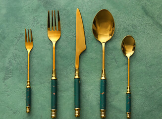 Elegant cutlery set on green background